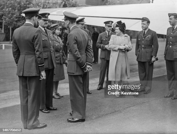 King George , Queen Elizabeth and Princess Elizabeth pictured with Royal Air Force personnel at an unidentified airfield prior to travelling to...