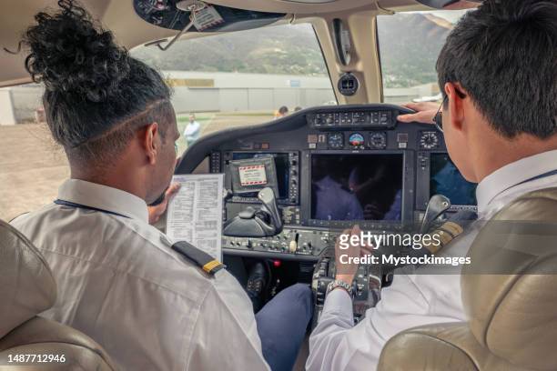 private jet pilots going through checklist inside the cockpit - aeroplane dashboard stock pictures, royalty-free photos & images