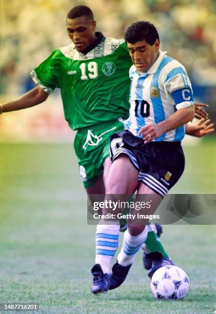 Argentina captain Diego Maradona shrugs off the challenge of Nigeria player Michael Emenalo during the FIFA 1994 World Cup match in Boston, U.