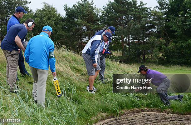 Phil Mickelson of the United States searches for his golf ball on the eighth hole during the first round of the 141st Open Championship at Royal...