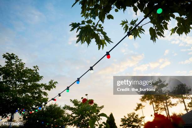 low angle view of string lights for party decoration against idyllic sky at sunset - string stock pictures, royalty-free photos & images