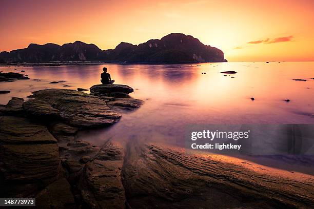 praying on the rock - silhouette sitting stock pictures, royalty-free photos & images