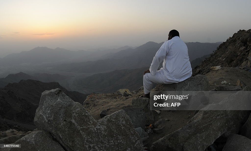 A man sits on the side of a hill waiting
