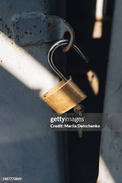 metal padlock with two keys on old garage door - open padlock stock pictures, royalty-free photos & images