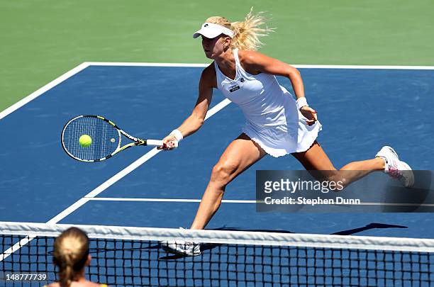 Urszula Radwanska of Poland hits a shot at the net past Melanie Oudin during day six of the Mercury Insurance Open Presented By Tri-City Medical at...