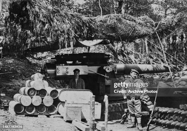 Camouflaged Canon de 164 mm Modèle 1893-1896 medium-caliber naval gun on a fixed mounting emplacement manned by Fusiliers Marins of the French Navy...