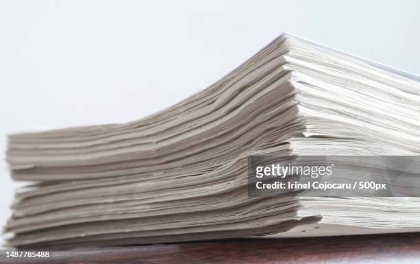 close-up of stacked newspapers on table against white background,romania - publikation stock pictures, royalty-free photos & images