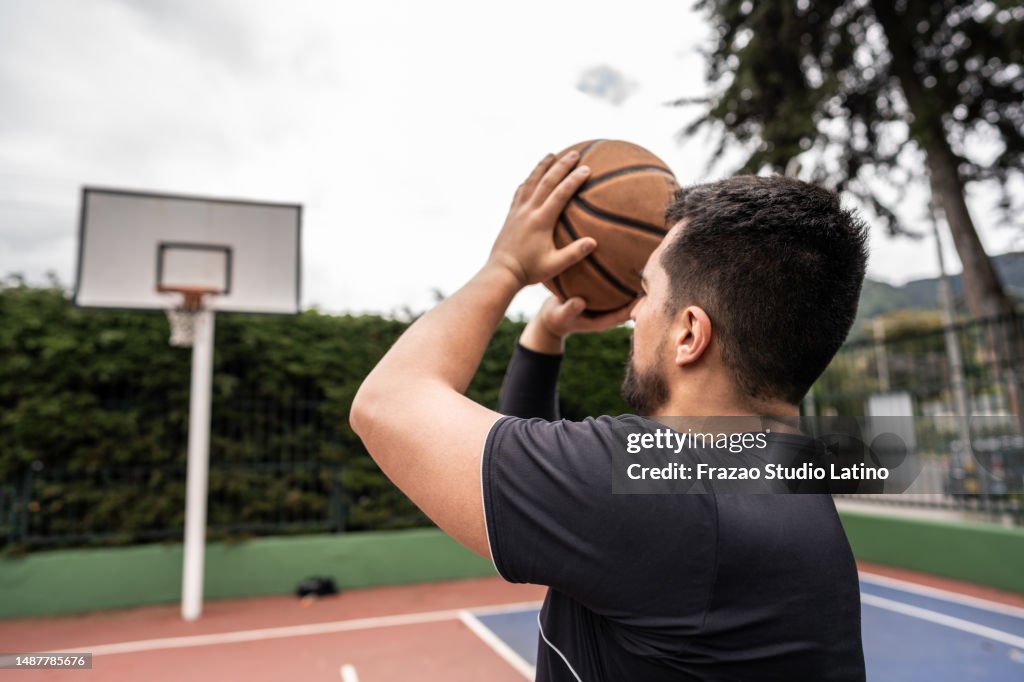 Young man playing basketball in a sports court
