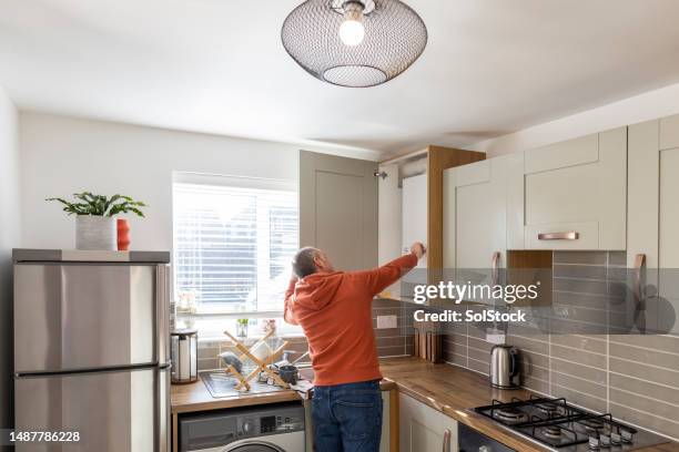 adjusting the boiler in the kitchen at home - caldeira imagens e fotografias de stock