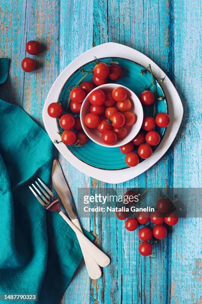 cherry tomatoes on blue and white plates - cherry tomatoes stock-fotos und bilder