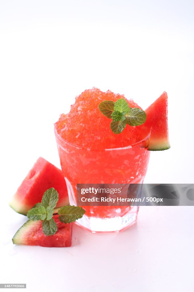 Close-up of strawberry smoothie in glass against white background