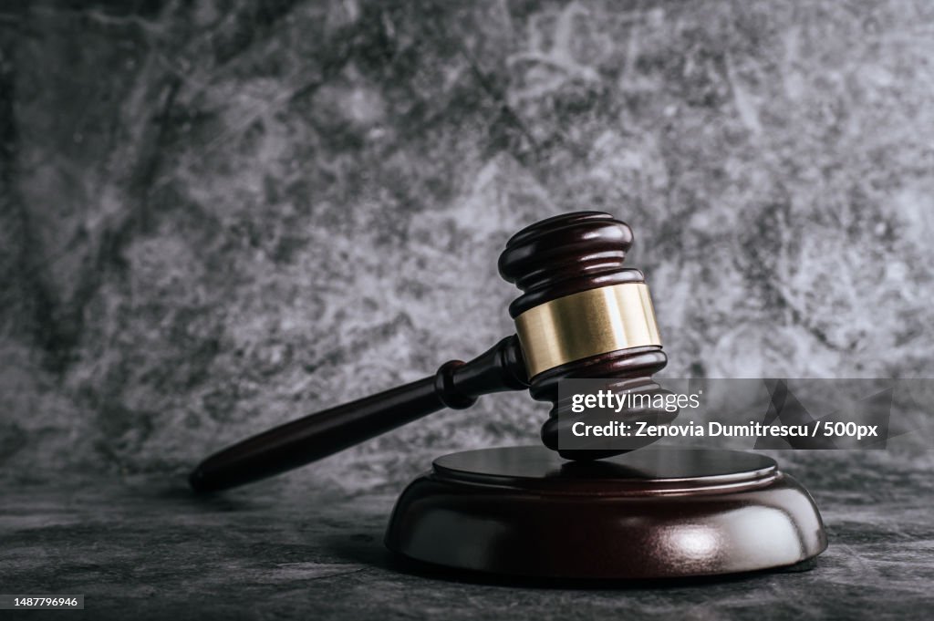 Wooden judges gavel on table in a courtroom or enforcement office,Romania