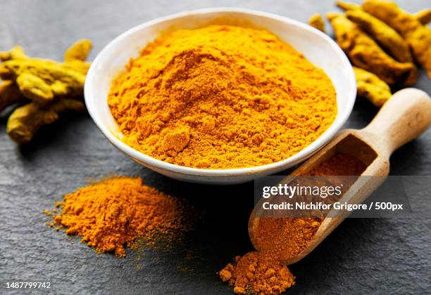 close-up of ground turmeric in bowl on table,romania - tumeric stock pictures, royalty-free photos & images