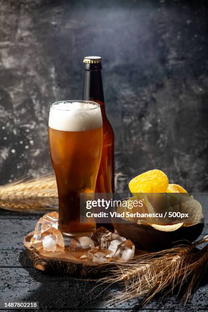 front view bottle of bear with glass full of bear on a dark background photo alcohol drink color wine,romania - romania bear stock pictures, royalty-free photos & images