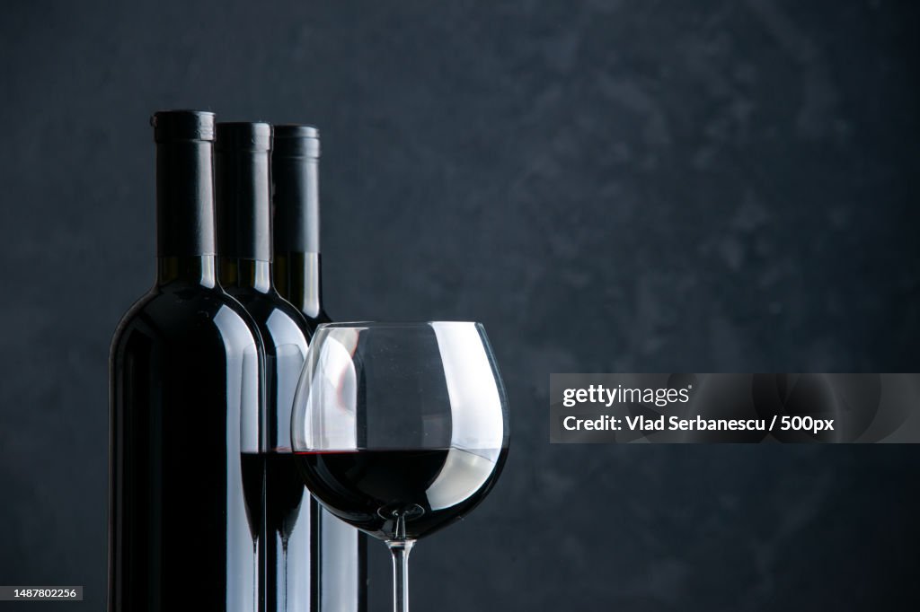 Front view bottles of wine with glass of wine on dark background alcohol beer grape color bar dinner photo restaurant free space,Romania