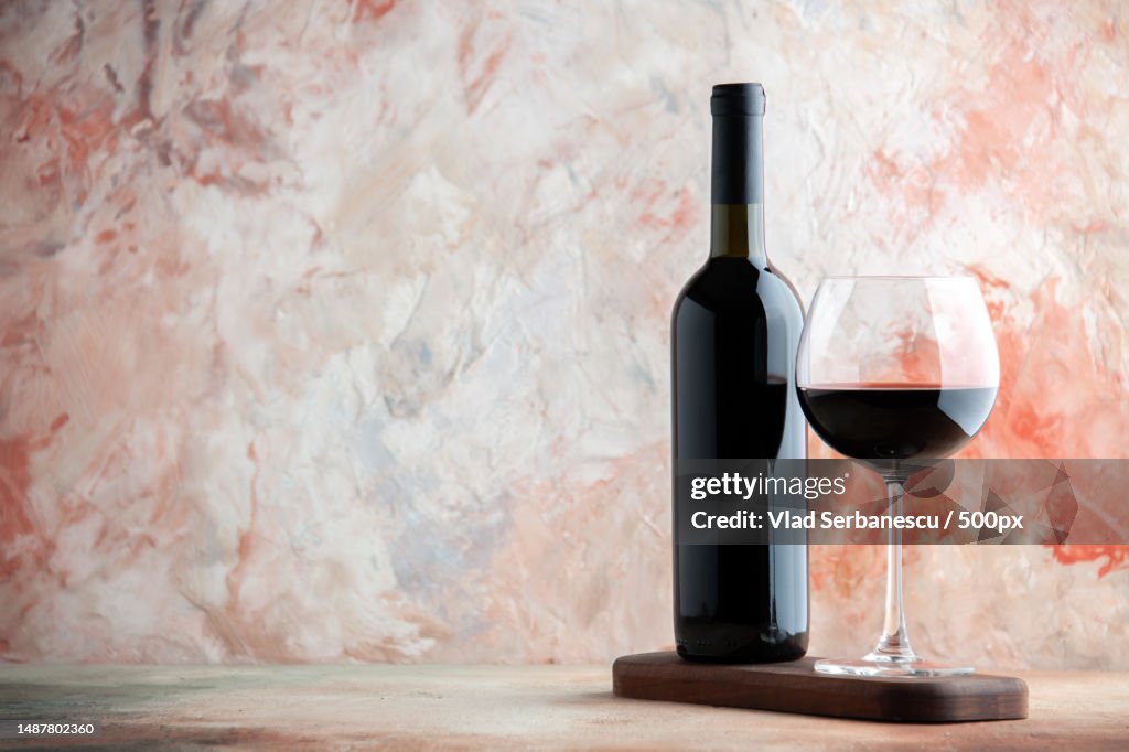Front view glass of wine with bottle and chocolate on light background alcohol bar champagne juice drink lemonade