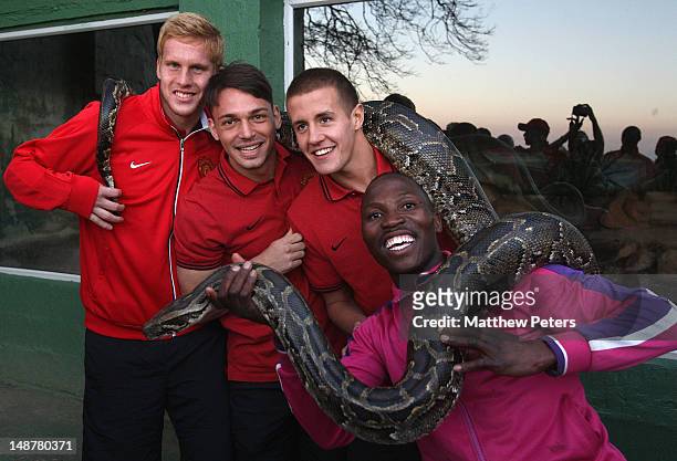 Ben Amos, Frederic Veseli and Scott Wootton of Manchester United pose with a snake at PheZulu Safari Park as part of their pre-season tour of South...