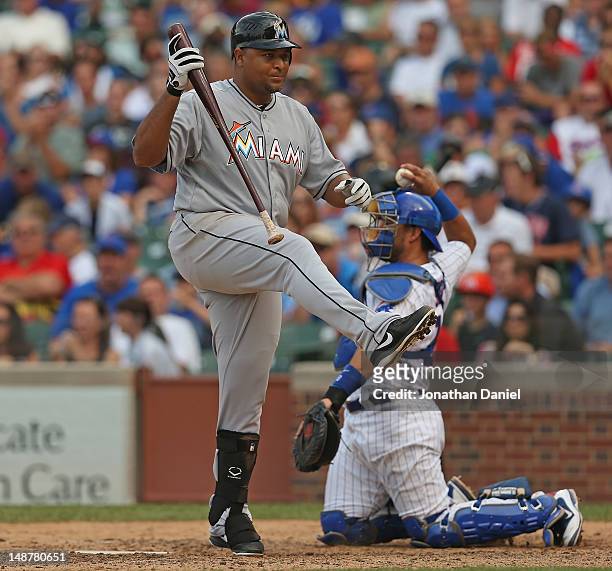 Carlos Lee of the Miami Marlins reacts after swinging and missing a pitch in the 9th inning as Geovany Soto of the Chicago Cubs throws the ball back...