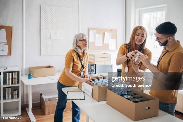 people working in charity donation center - distribution center stockfoto's en -beelden