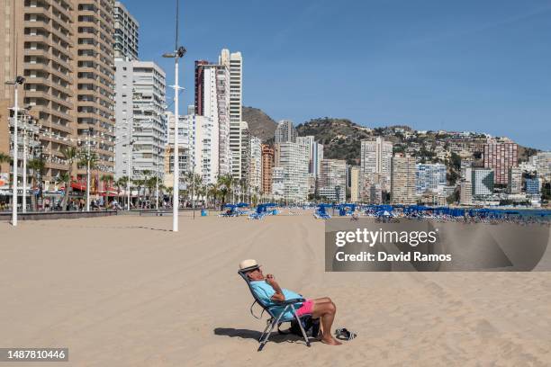 Man sunbaths in Levante beach on May 05, 2023 in Benidorm, Spain. On May 6 King Charles III will be crowned at Westminster Abbey, as the world...