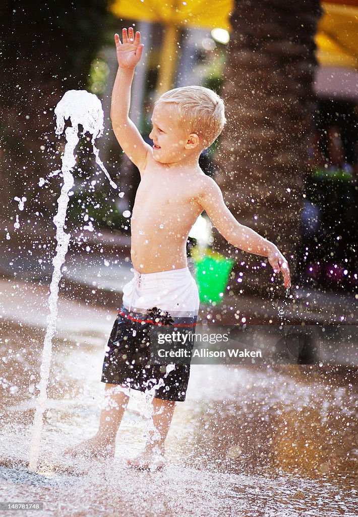 Boy playing at splash pad