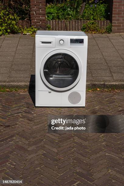 white washing machine stands on the street - old fridge stock pictures, royalty-free photos & images