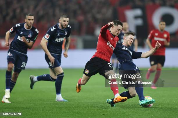 Florian Wirtz of Bayer 04 Leverkusen is challenged by Florian Kainz of 1.FC Koeln during the Bundesliga match between Bayer 04 Leverkusen and 1. FC...