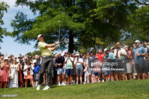 Rory McIlroy of Northern Ireland plays an approach shot on the eighth hole as fans look on during the second round of the Wells Fargo Championship at...