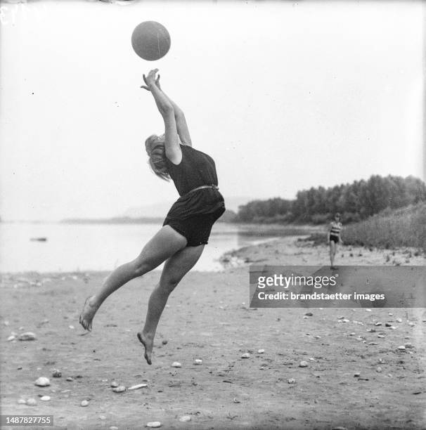 Woman doing gymnastics with a ball on a beach, circa 1930. Photograph by Richard Werian.