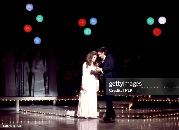 American singer, songwriter and dancer June Carter Cash and her husband, Country singer Johnny Cash sing on stage during an episode of The Johnny...