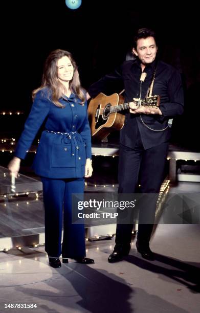 American singer, songwriter and dancer June Carter Cash and her husband, Country singer Johnny Cash sing on stage during an episode of The Johnny...