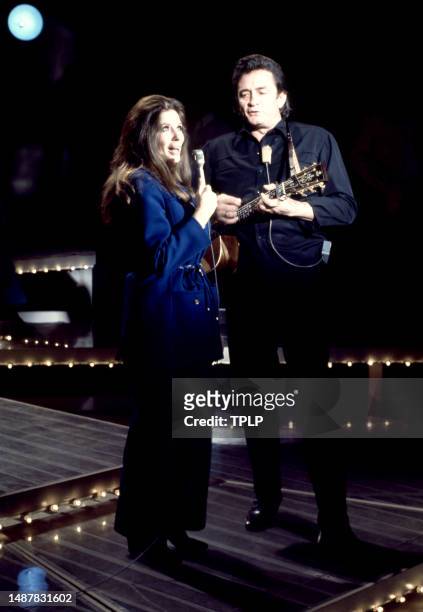 American singer, songwriter and dancer June Carter Cash and her husband, Country singer Johnny Cash sing on stage during an episode of The Johnny...