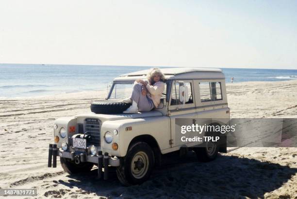 American actress Farrah Fawcett poses on a jeep during the Faberge commercial shoot in Los Angeles, California, circa 1977.