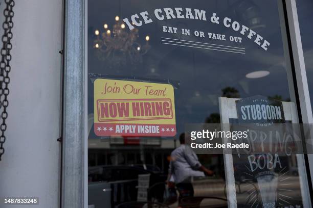 Now Hiring' sign posted outside of a restaurant looking to hire workers on May 05, 2023 in Miami, Florida. A report by the Bureau of Labor Statistics...