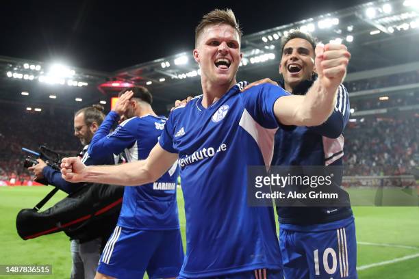 Marius Bulter of Schalke celebrates scoring his teams third goal of the game from the penalty spot with teammates during the Bundesliga match between...