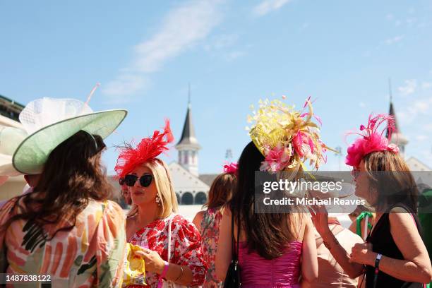 Spectators wearing festive hats look on in the paddock ahead of the 149th running of the Kentucky Derby at Churchill Downs on May 05, 2023 in...