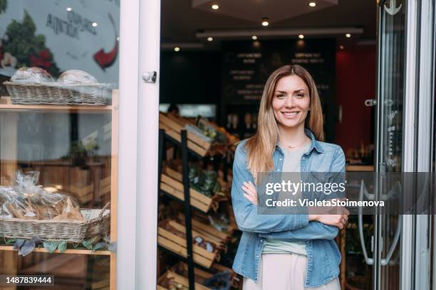 cheerful business owner of an organic market standing at the entrance. - vendedor de legumes e fruta imagens e fotografias de stock