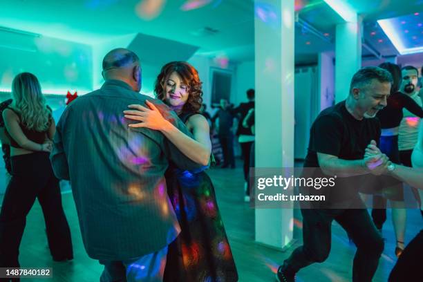 mature couple dancing salsa at the party - salsa dancing stockfoto's en -beelden