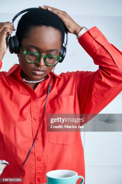 beautiful black girl with headphones, enjoying music from the smart phone - mp3 juices 個照片及圖片檔