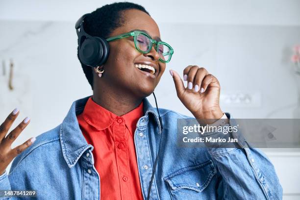 beautiful black girl with headphones, enjoying music from the smart phone - mp3 juices 個照片及圖片檔