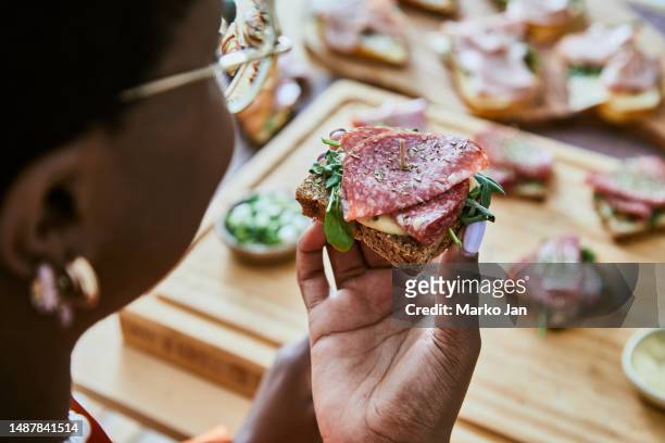 mujer disfrutando de sandwic - cold cuts fotografías e imágenes de stock