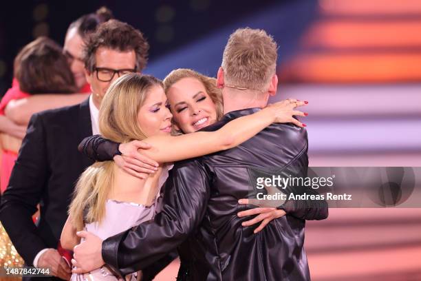 Hosts Daniel Hartwich and Victoria Swarovski embrace Isabel Edvardsson and Jens 'Knossi' Knossalla who have been voted out of the show, on stage...