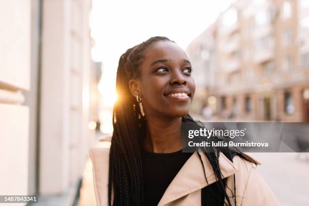 young businesswoman looking at office buildings enjoying fresh evening air - skin tone stock pictures, royalty-free photos & images