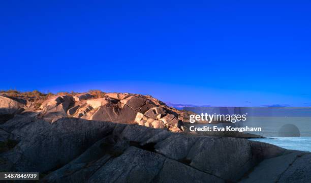 the sun is coming low and making interesting shadows on the fascinating cliffs by the coast - cliff texture stockfoto's en -beelden