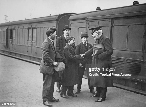 David Crichton Lamb of the Salvation Army bids farewell to a group of orphaned boys from the Dr Barnardo's Homes, as they leave Waterloo Station in...