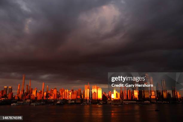 The sun sets across the skyline of midtown Manhattan as rain clouds pass over New York City on May 5 as seen from Weehawken, New Jersey.