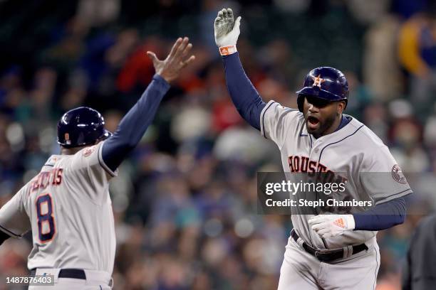 Yordan Alvarez celebrates his threerun home run with third base coach Gary Pettis of the Houston Astros during the third inning against the Seattle...