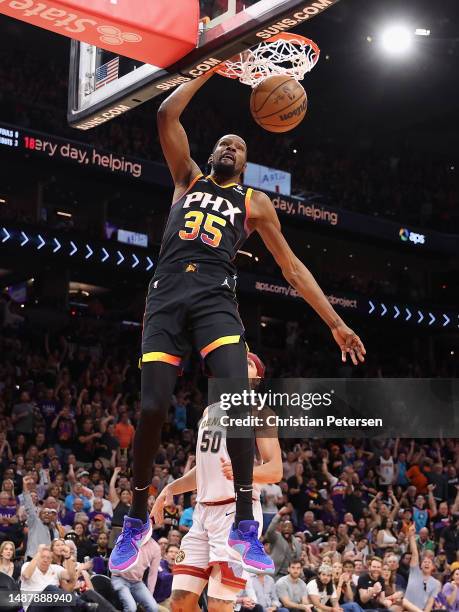 Kevin Durant of the Phoenix Suns slam dunks the ball against the Denver Nuggets during the second half of Game Three of the NBA Western Conference...