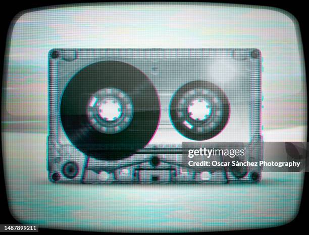 cassette audio tape with glitch vhs effect on tube tv screen - filmvorführung stock-fotos und bilder