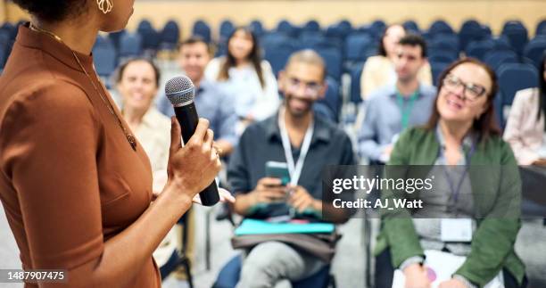 businesswoman with a mic speaking to audience at business conference - holding microphone stock pictures, royalty-free photos & images